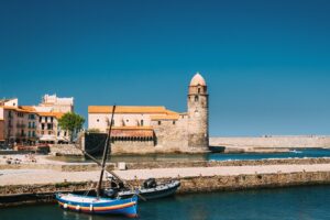 Collioure, France. Boats Moored On Berth Near The Church Of Our